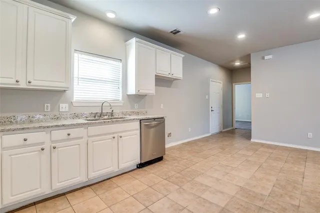 a kitchen with granite countertop white cabinets and stainless steel appliances