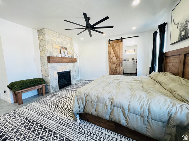 100 Whit Lane Georgetown, ID 83239 - Photo 29 of 76 Bedroom with a barn door, a ceiling fan, and a stone fireplace