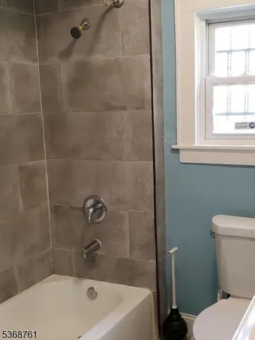 a white bath tub sitting next to a toilet