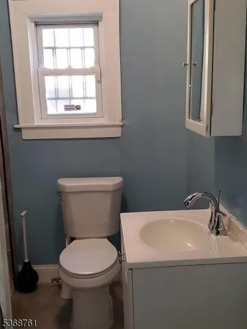 a bathroom with a sink a toilet and a window