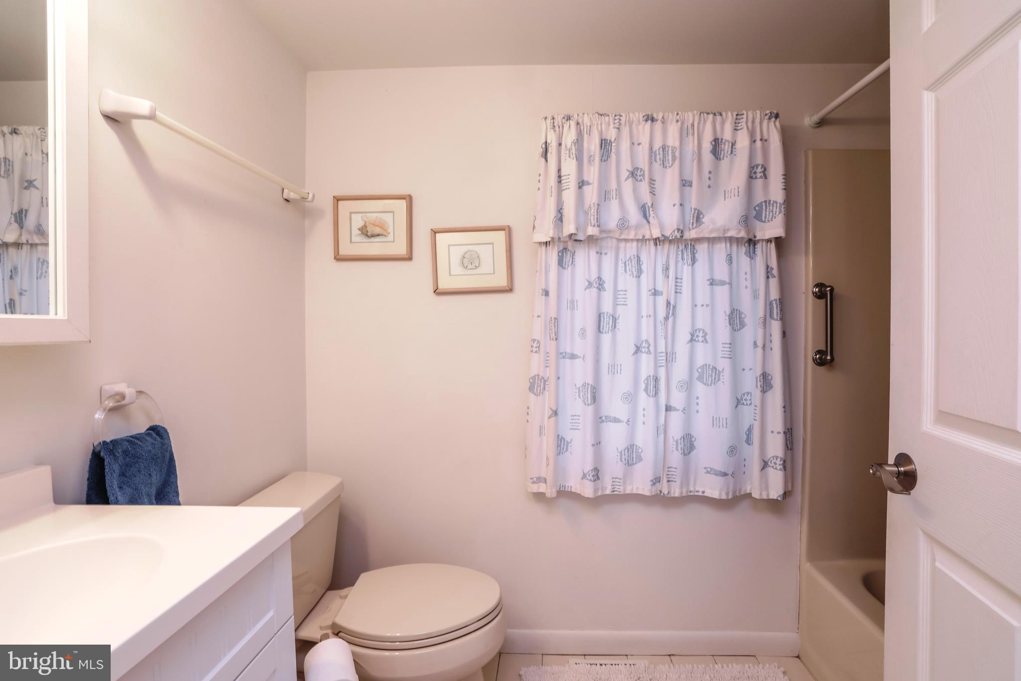 24 Maiden Lane Harvey Cedars, NJ 08008 - Photo 19 of 37 a bathroom with a toilet and a shower curtain