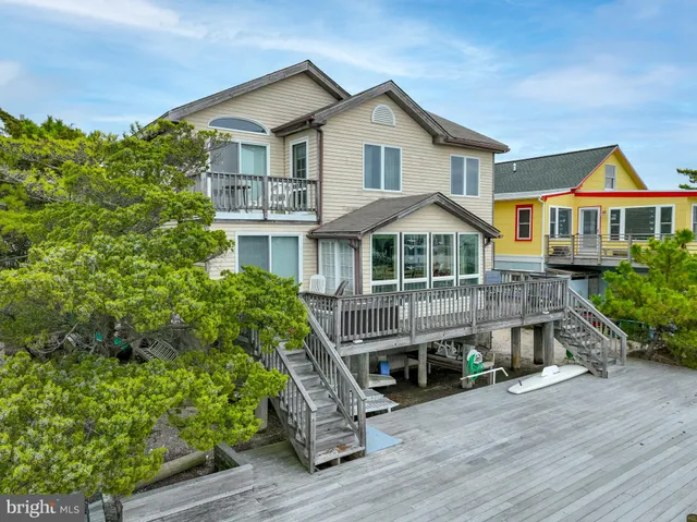 a front view of a house with a yard and potted plants