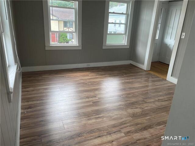 61 8th Street Derby, CT 06418 - Photo 2 of 12 an empty room with wooden floor and windows