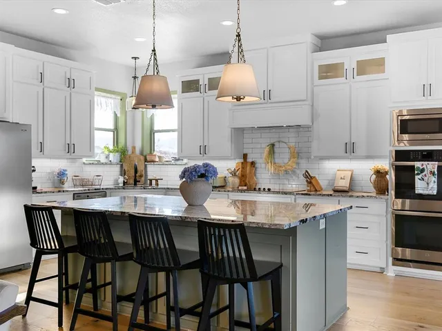 a kitchen with kitchen island granite countertop a sink a center island and cabinets