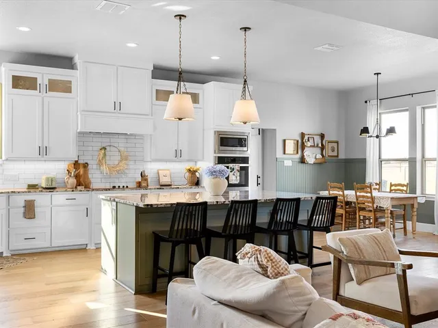 a kitchen with a table chairs sink and cabinets