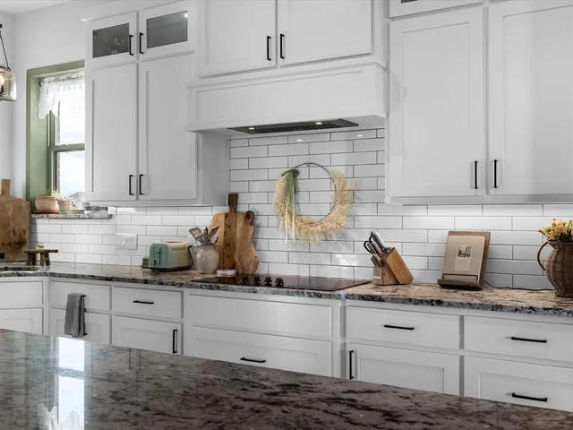 a kitchen with granite countertop white cabinets and white appliances