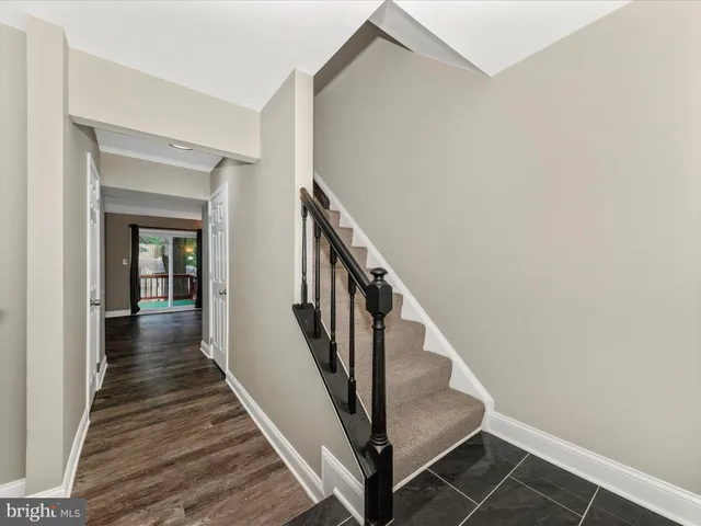 a view of a hallway with wooden floor and entryway