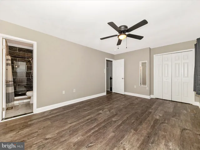 a view of an empty room with window and a ceiling fan