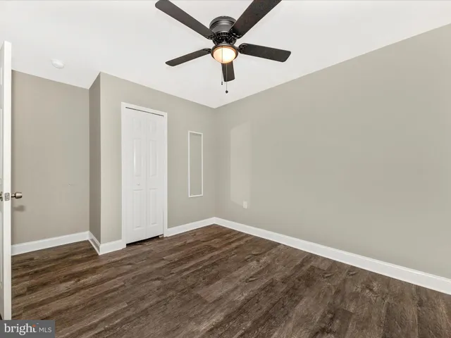 a view of a room with wooden floor and a ceiling fan