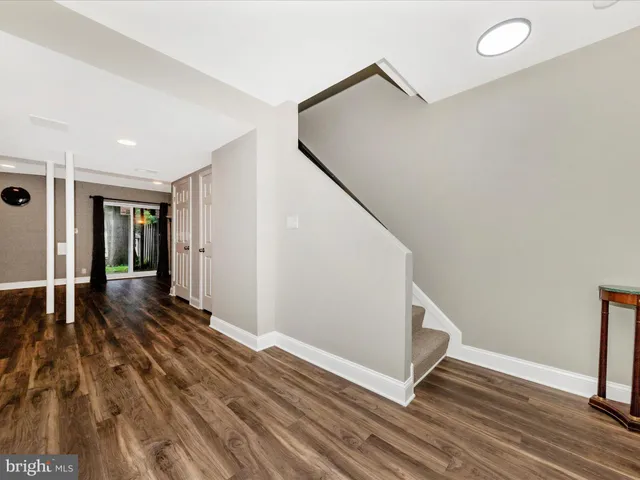 a view of a hallway with wooden floor and staircase