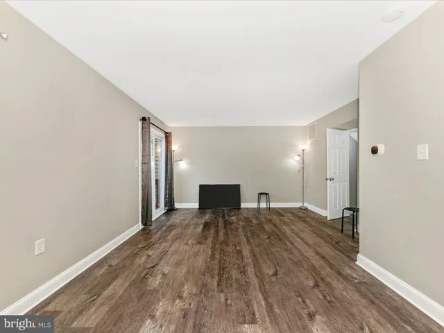 a view of a big room with wooden floor and a bathroom