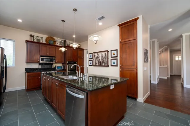 a kitchen with stainless steel appliances granite countertop a sink a stove and a refrigerator