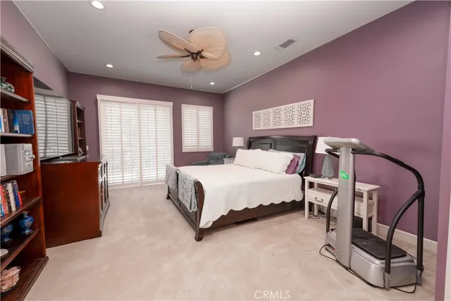 a bedroom with a bed a bookshelf and a chandelier