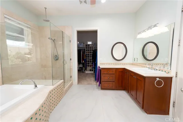 a spacious bathroom with a sink a toilet a mirror and shower