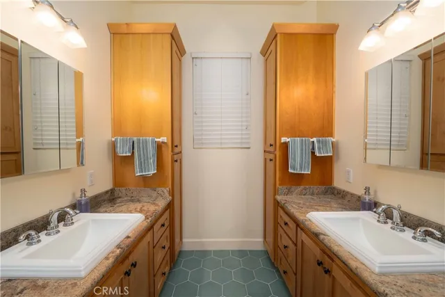 a bathroom with a double vanity sink a mirror and a shower