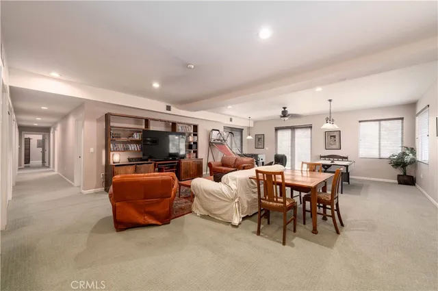 a living room with furniture a flat screen tv and a large window