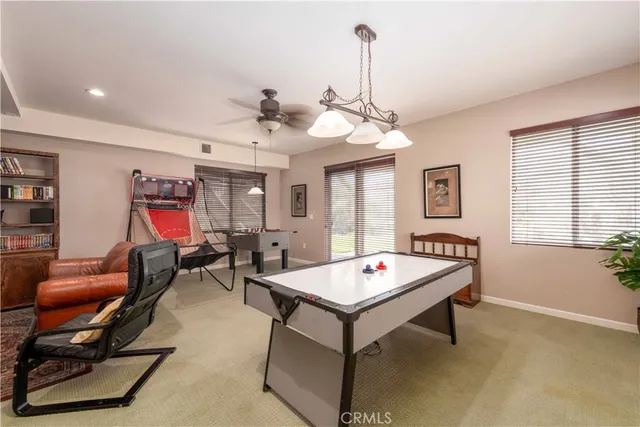 a living room with furniture pool table and window