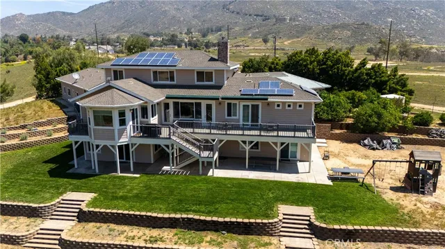 a aerial view of a house with a yard table and chairs