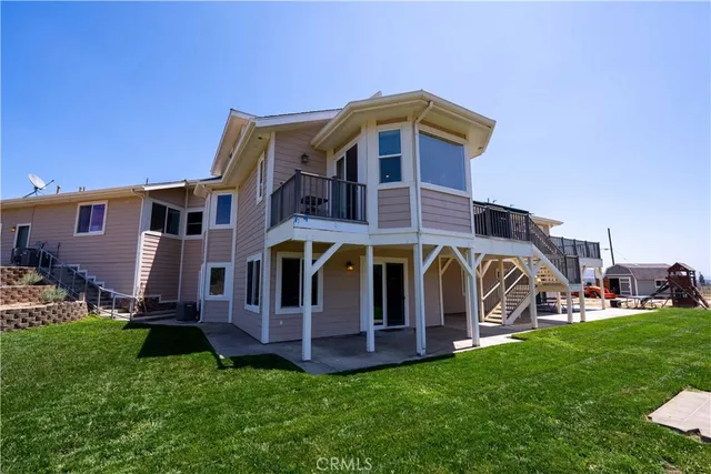 an aerial view of a house with a yard and lake view