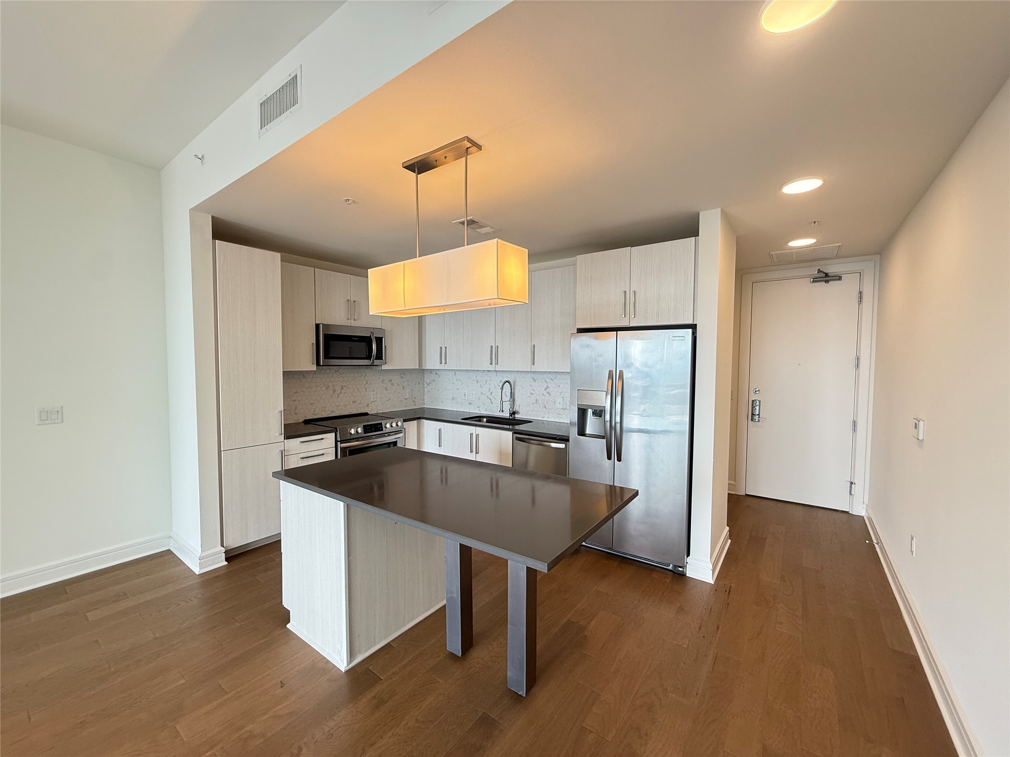 a kitchen with stainless steel appliances granite countertop a sink a stove and a refrigerator