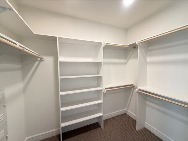 a view of walk in closet with empty racks