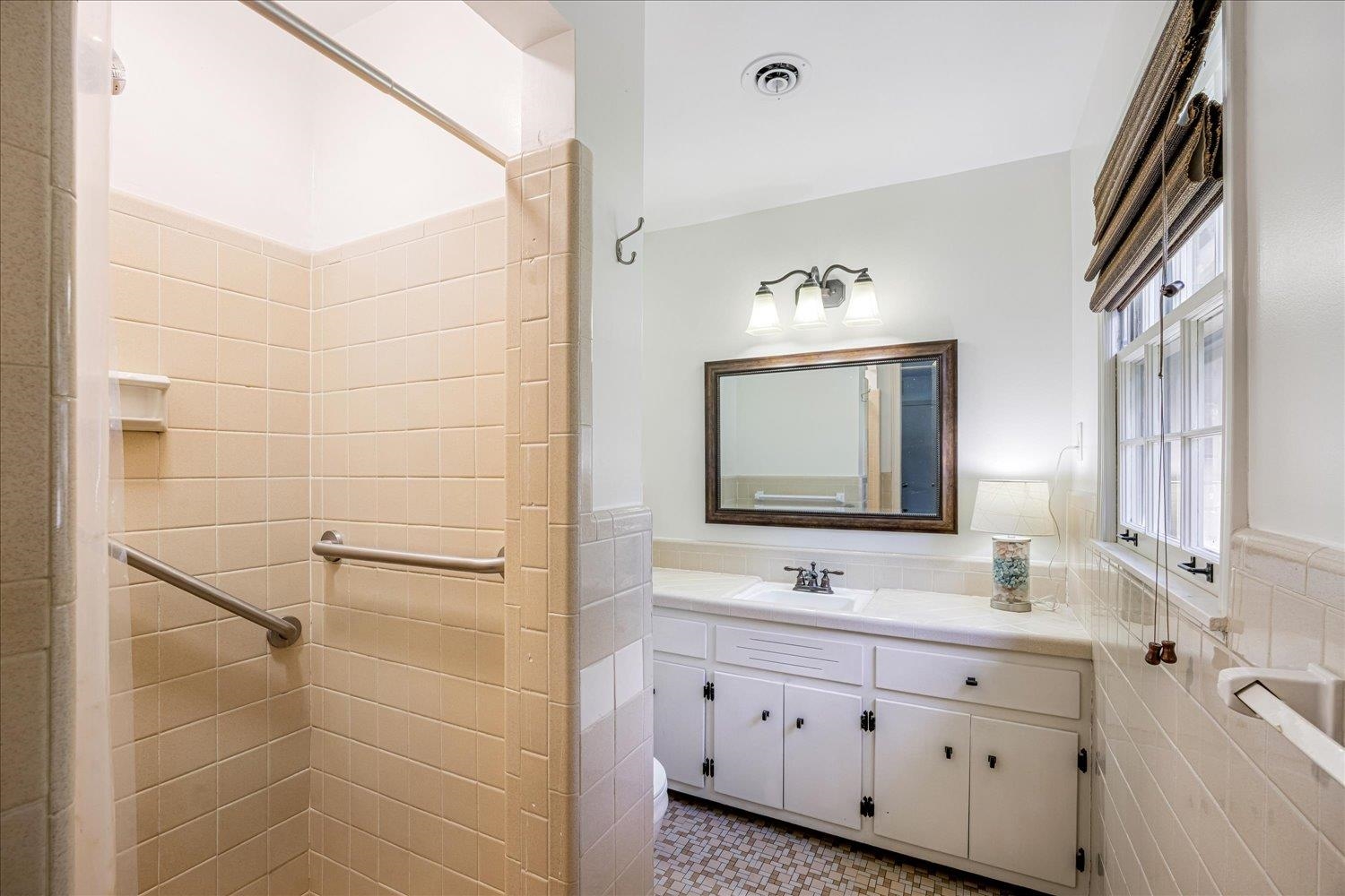 5323 Dee Road Memphis, TN 38117 - Photo 27 of 40 a bathroom with a granite countertop double vanity sink a mirror and a shower