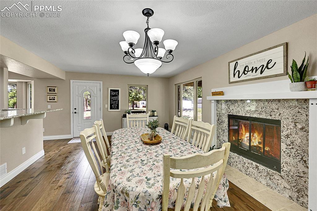 17350 Goshawk Road Colorado Springs, CO 80908 - Photo 15 of 50 a view of a dining room with furniture wooden floor and chandelier