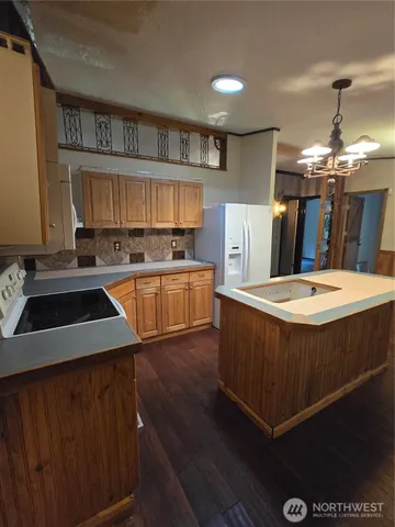 a kitchen with stainless steel appliances a sink a stove a refrigerator and cabinets