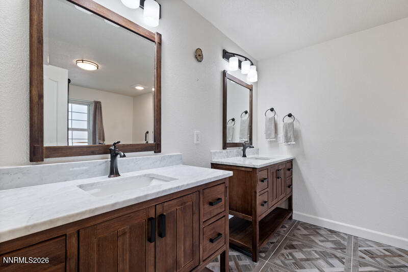 1060 Penelope Drive Fallon, NV 89406 - Photo 14 of 32 a bathroom with a double vanity sink and a mirror