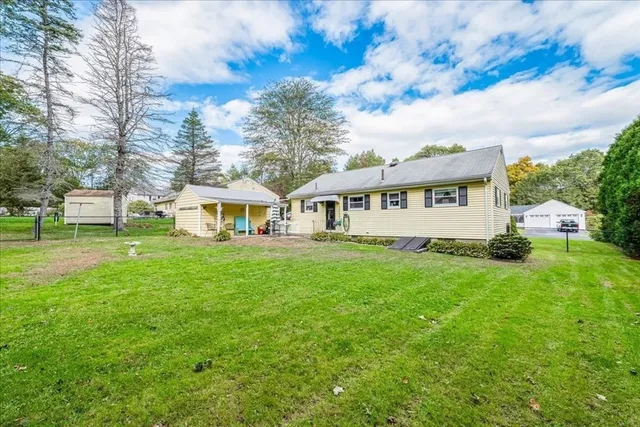 a view of a house with backyard and sitting area