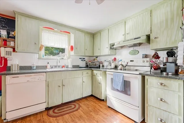 a kitchen with granite countertop white cabinets and white appliances