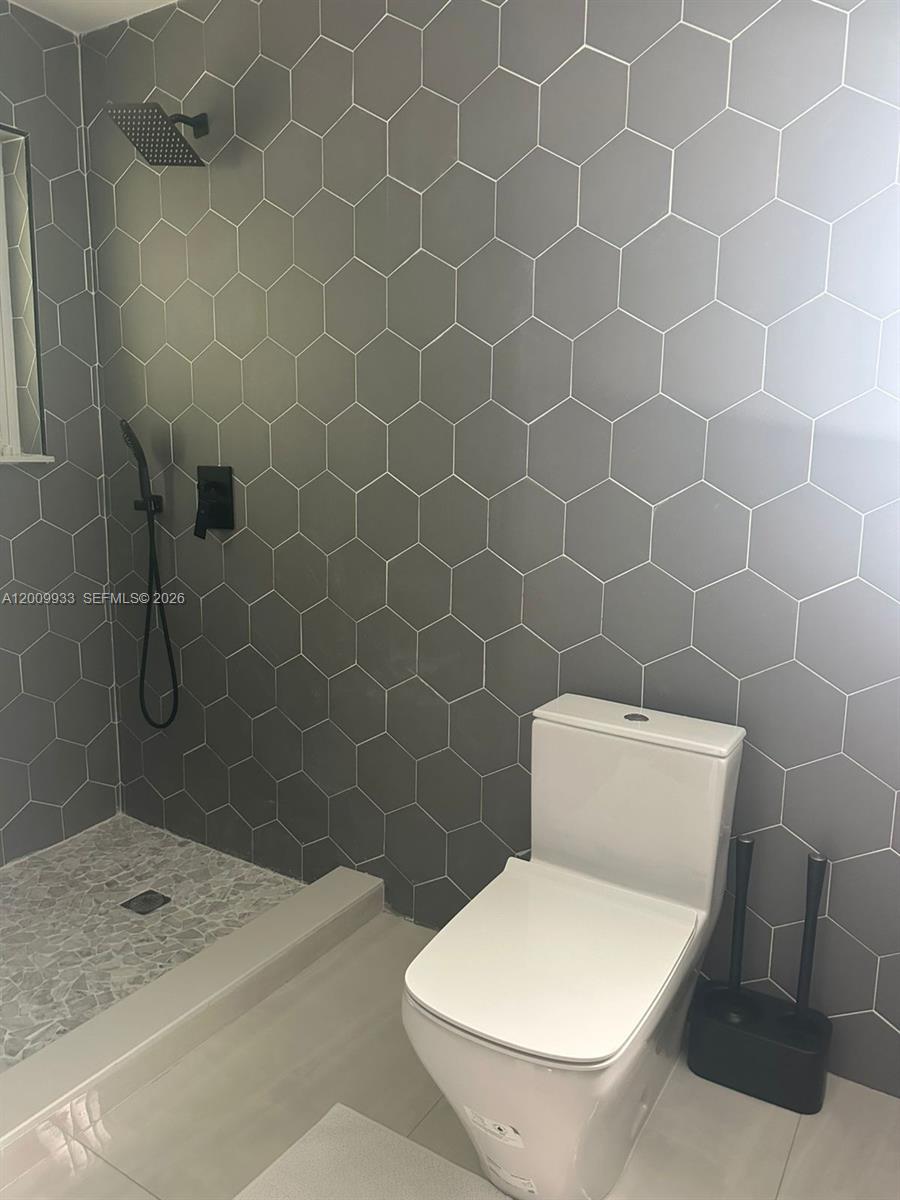 1030 Northeast 83rd Street Miami, FL 33138 - Photo 11 of 11 a white toilet sitting next to a bath tub
