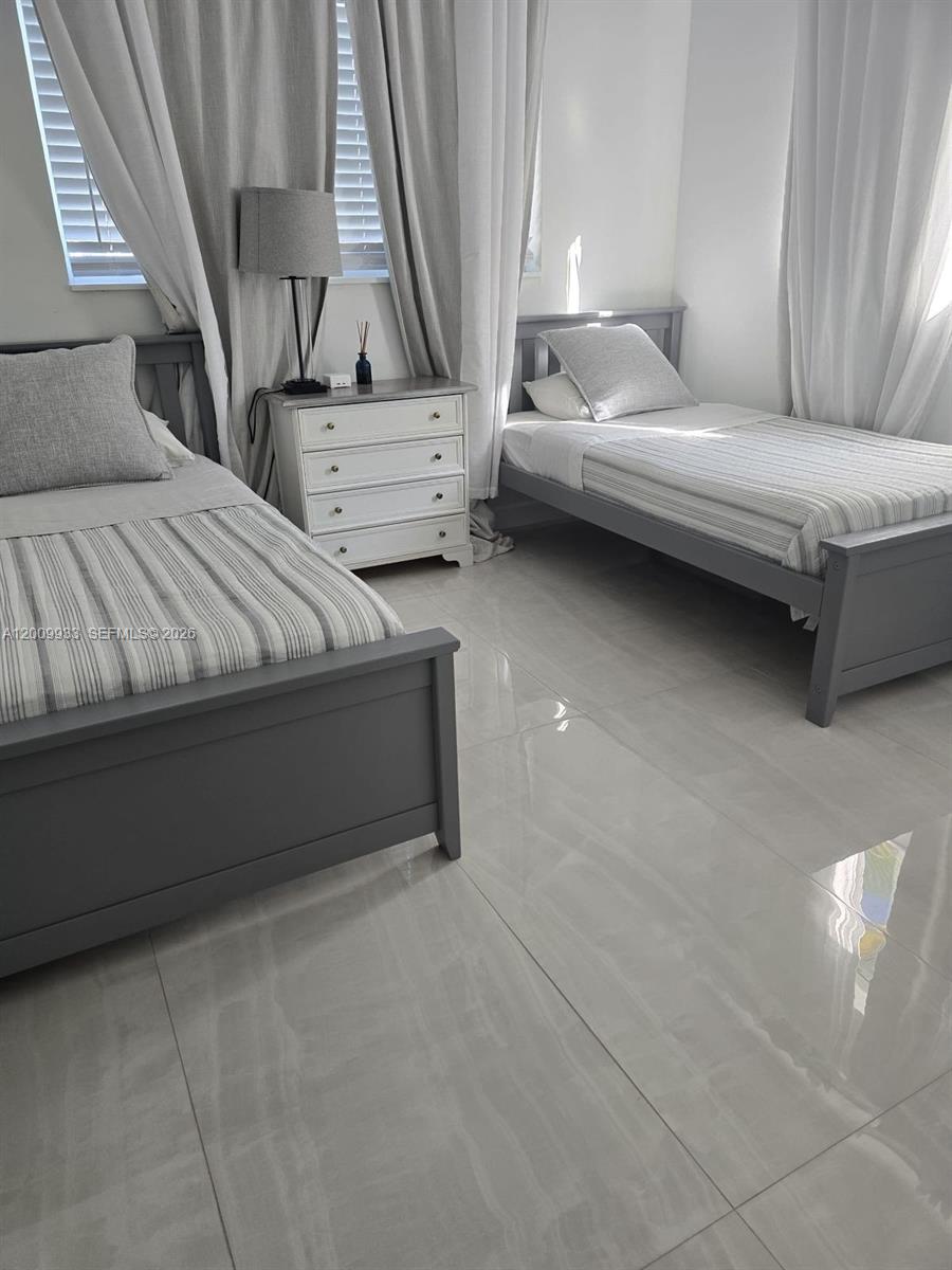 1030 Northeast 83rd Street Miami, FL 33138 - Photo 3 of 11 a bedroom with a bed and a couch