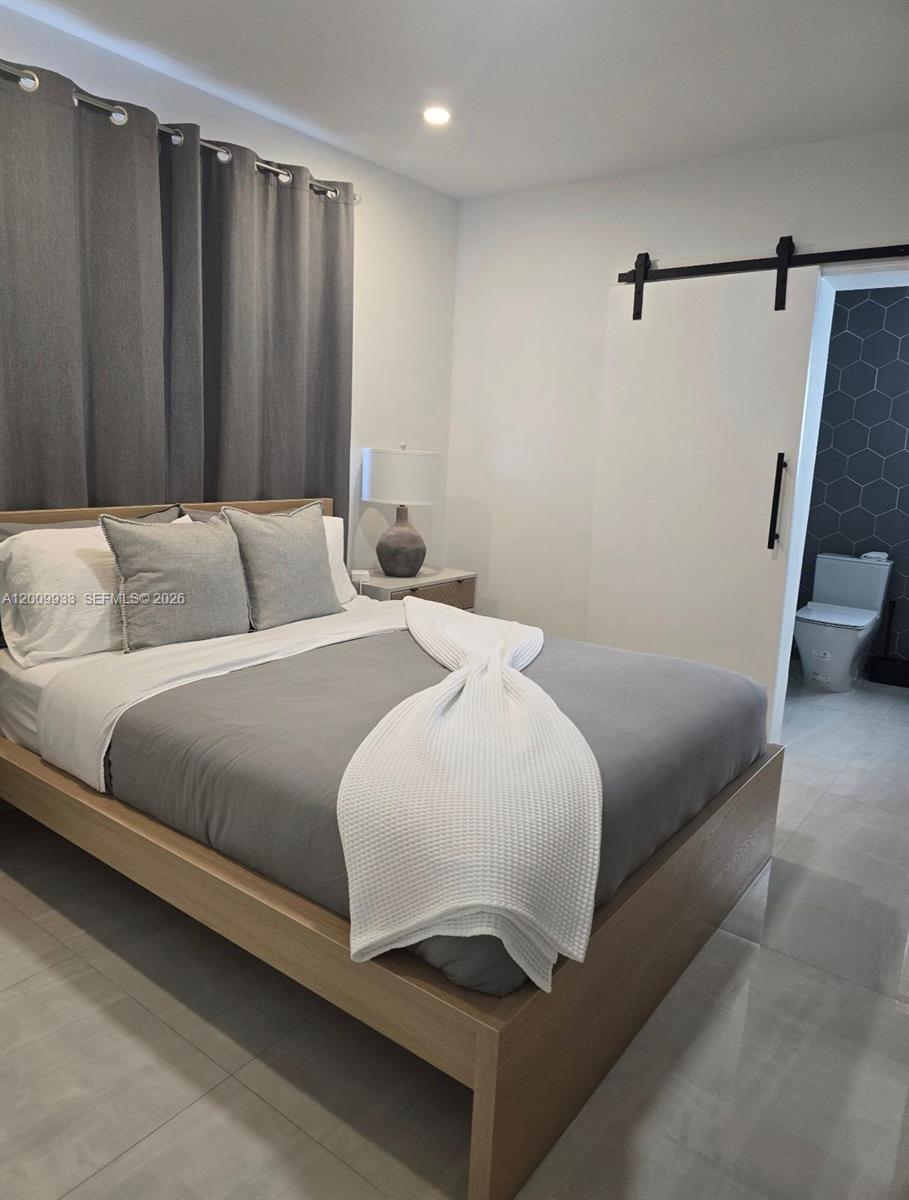 1030 Northeast 83rd Street Miami, FL 33138 - Photo 6 of 11 a bedroom with a bed and a mirror