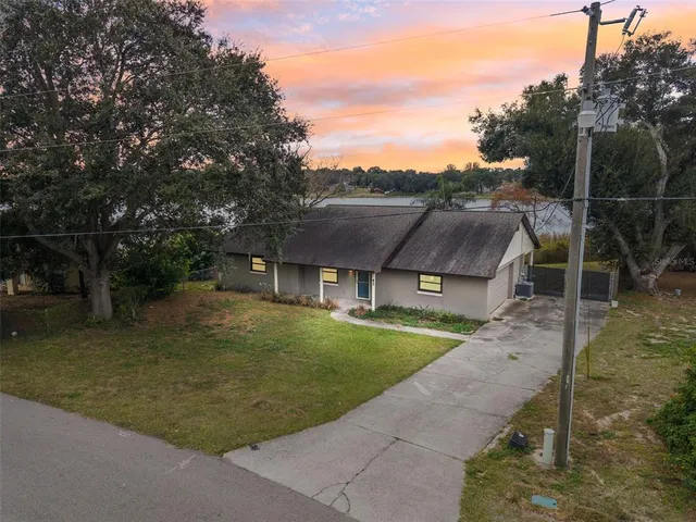 a view of a big house with a big yard and potted plants