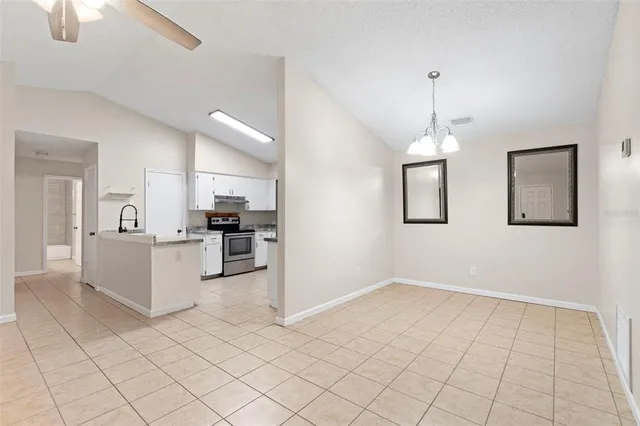 a kitchen with granite countertop a stove sink and refrigerator
