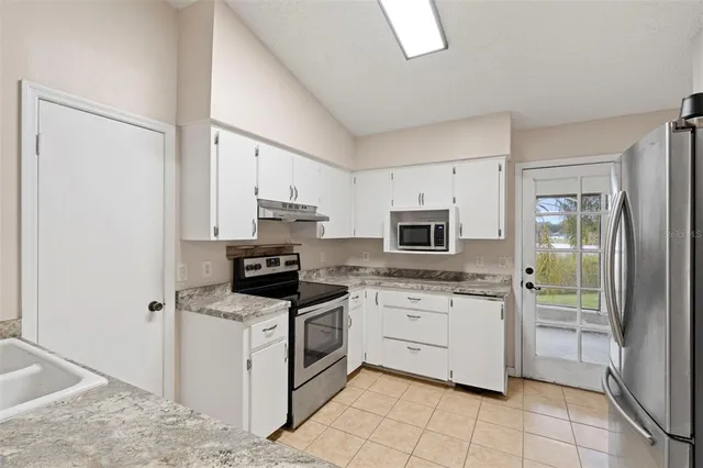an empty room with white walls and ceiling fan