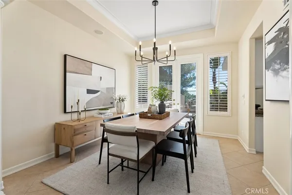 a living room with furniture kitchen view and a chandelier