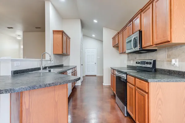 a kitchen with stainless steel appliances granite countertop a sink stove and cabinets