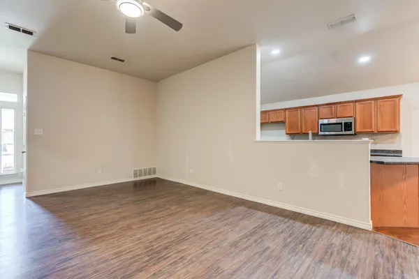 a view of a kitchen with wooden floor and a ceiling fan
