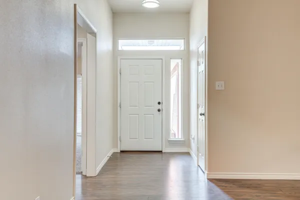 a view of a hallway with wooden floor