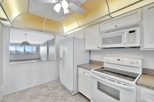 a kitchen with white cabinets white stainless steel appliances and sink