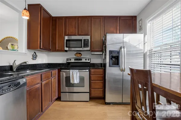 a kitchen with stainless steel appliances granite countertop a stove a sink dishwasher and a refrigerator