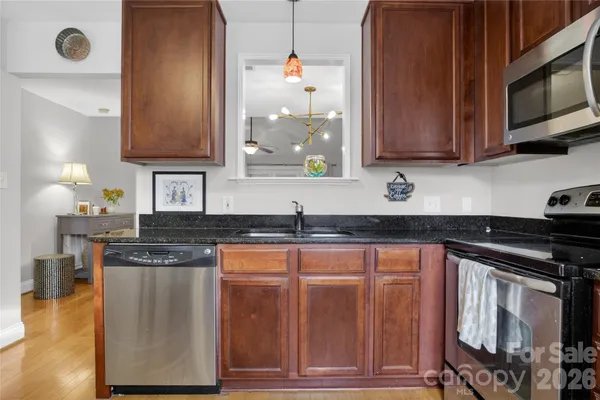 a kitchen with stainless steel appliances granite countertop a sink stove and microwave