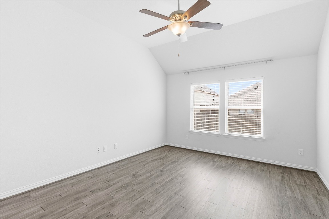 22020 Abigail Way Pflugerville, TX 78660 - Photo 12 of 25 an empty room with wooden floor fan and windows