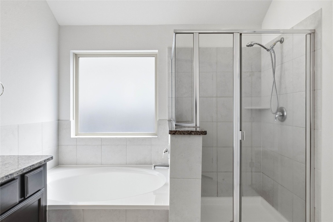 22020 Abigail Way Pflugerville, TX 78660 - Photo 17 of 25 a bathroom with a bathtub and a shower