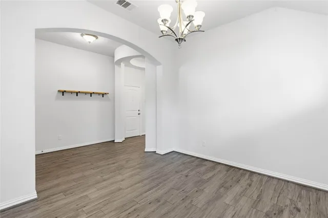 an empty room with wooden floor and ceiling fan