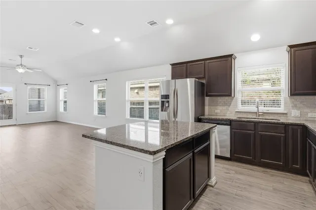 a kitchen with stainless steel appliances granite countertop a sink stove and refrigerator