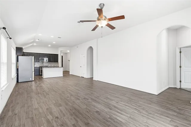 a view of empty room with wooden floor and window