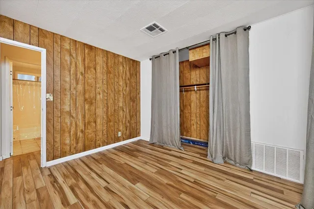 a view of a room with wooden floor and a bathroom